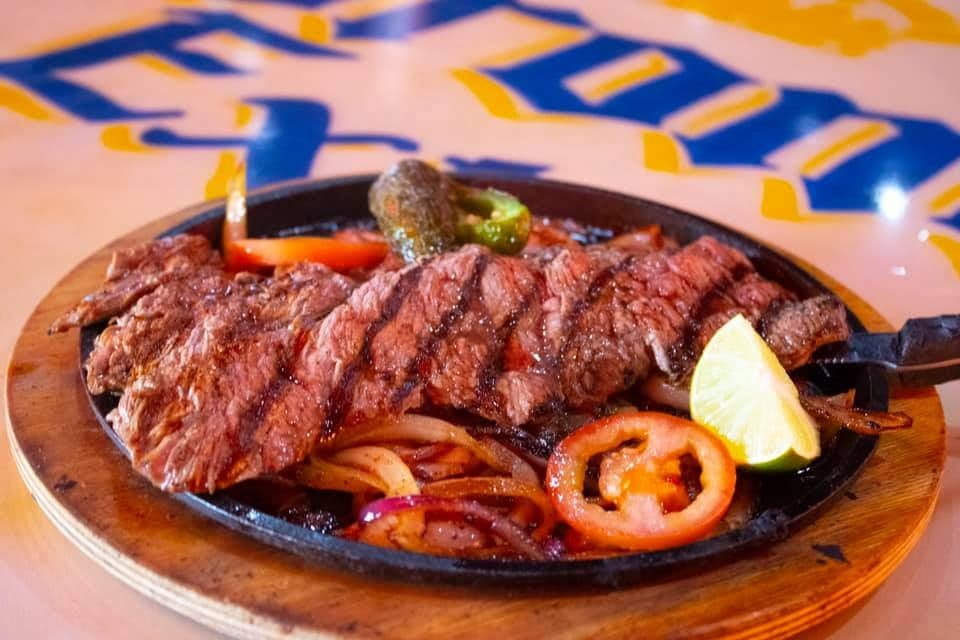 Fajitas sizzling off the flat-top.
